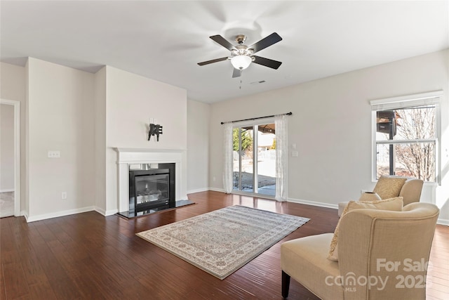 living room with ceiling fan and dark hardwood / wood-style flooring