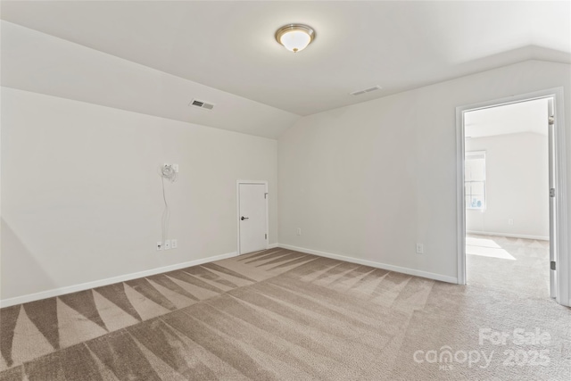 carpeted spare room with lofted ceiling