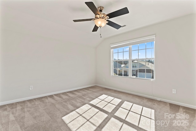 carpeted empty room featuring vaulted ceiling and ceiling fan