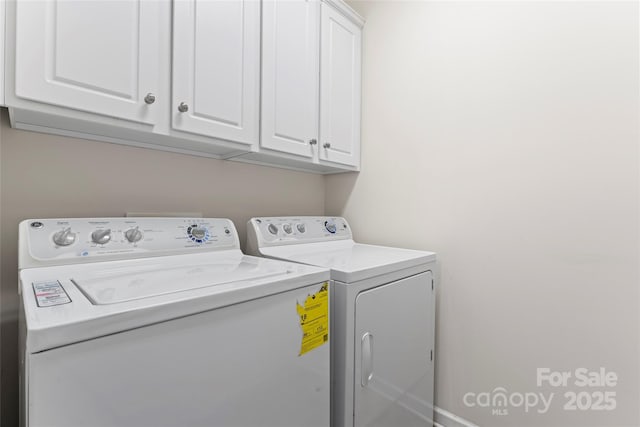 clothes washing area with cabinets and separate washer and dryer