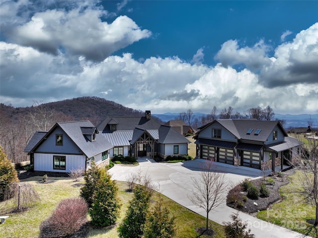 view of front of home with a mountain view, metal roof, concrete driveway, and a standing seam roof