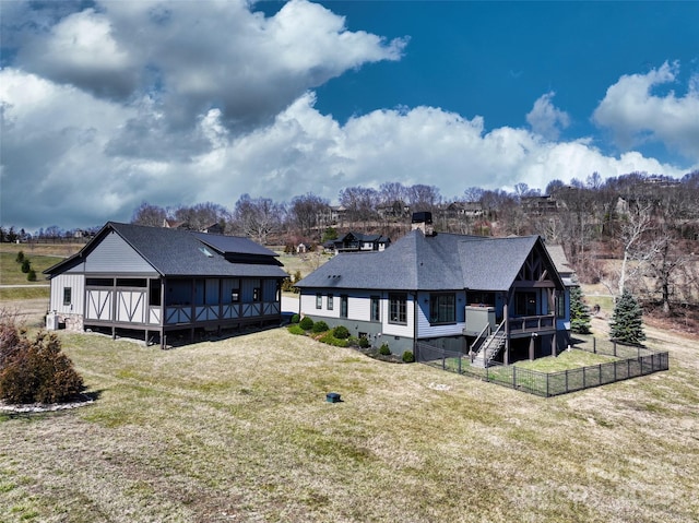 rear view of property featuring a shingled roof, a yard, fence, and crawl space