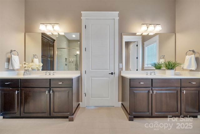 bathroom featuring walk in shower, two vanities, and a sink