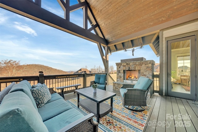 deck with an outdoor living space with a fireplace