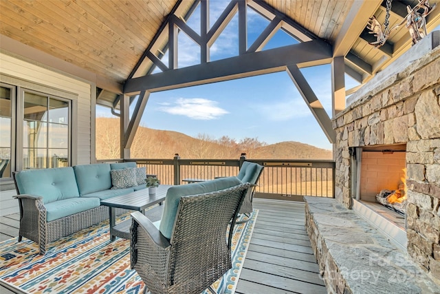 wooden terrace featuring an outdoor living space with a fireplace and a mountain view