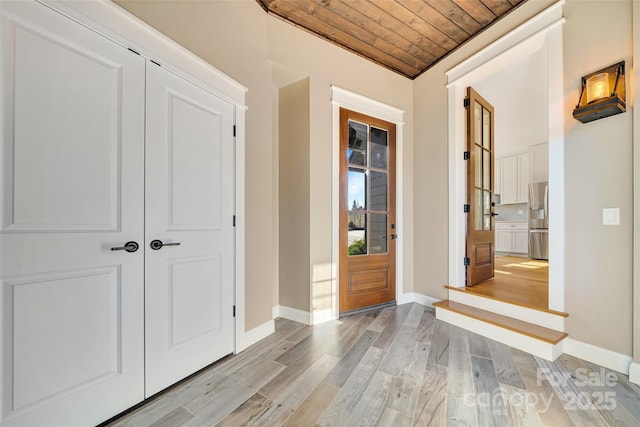 interior space with wooden ceiling, baseboards, and light wood finished floors