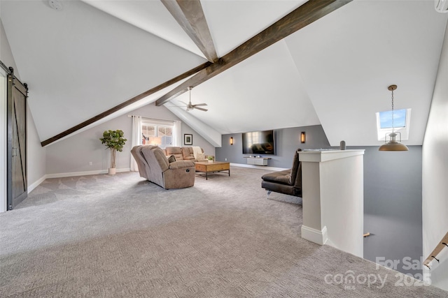 carpeted living area with a barn door, vaulted ceiling with skylight, baseboards, and ceiling fan