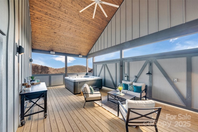 wooden deck featuring an outdoor living space, a ceiling fan, and a hot tub