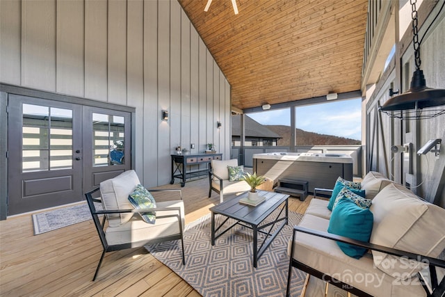 wooden terrace featuring french doors, a mountain view, outdoor lounge area, and a hot tub