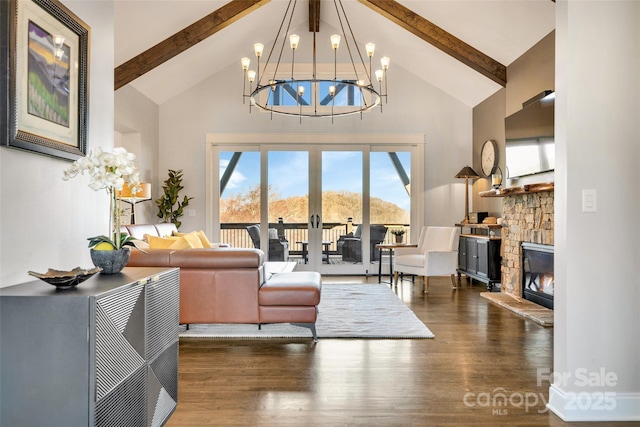 living room with beamed ceiling, high vaulted ceiling, a stone fireplace, and wood finished floors