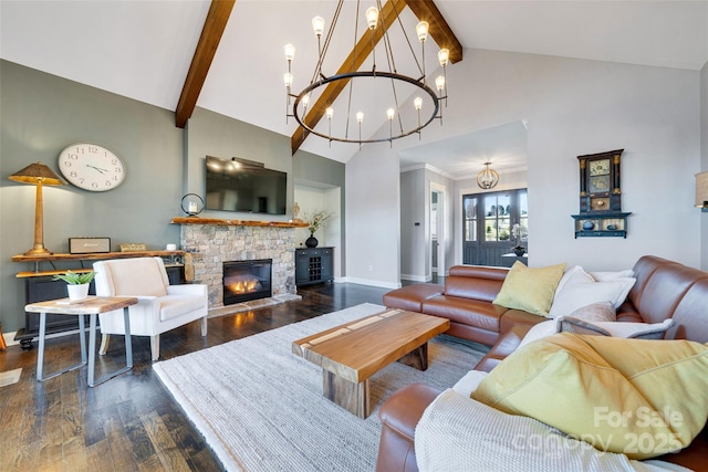 living room with baseboards, beam ceiling, dark wood-style flooring, a stone fireplace, and a notable chandelier