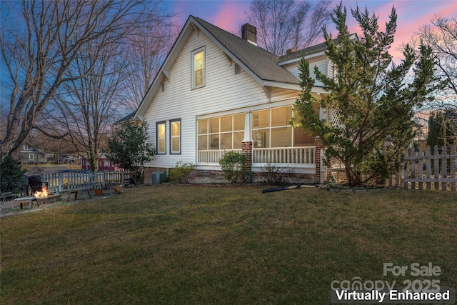 back house at dusk with a lawn