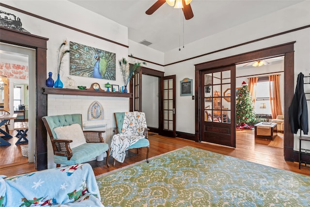 sitting room with ceiling fan, french doors, and wood-type flooring