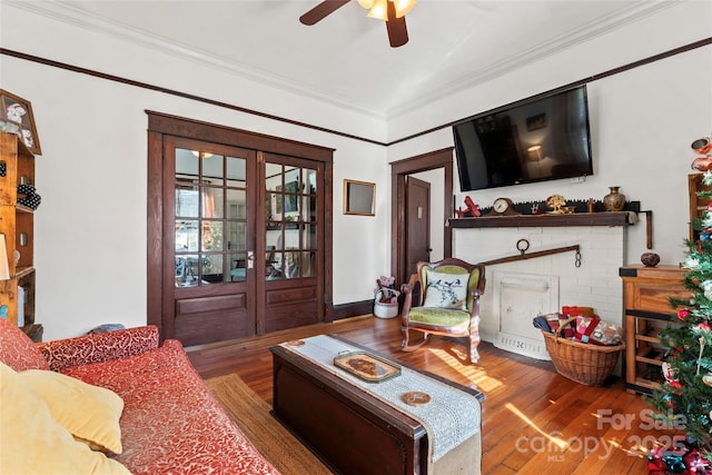 living room with ceiling fan, crown molding, and hardwood / wood-style floors