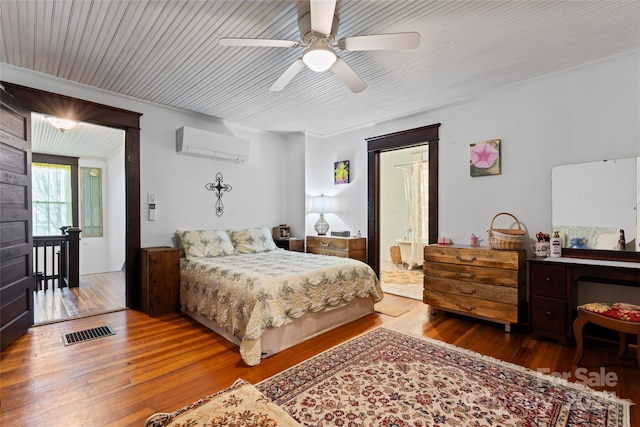 bedroom featuring ceiling fan, a wall mounted air conditioner, and hardwood / wood-style flooring