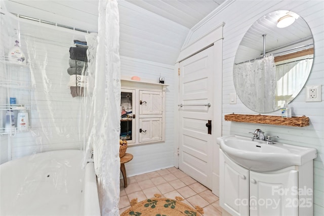 bathroom with a tub to relax in, tile patterned flooring, wood walls, vanity, and lofted ceiling