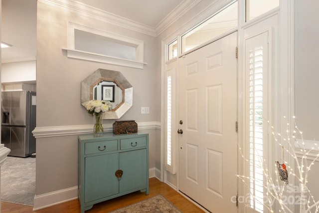 entrance foyer featuring a wealth of natural light, crown molding, and hardwood / wood-style flooring