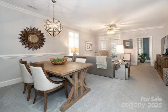 dining room featuring ceiling fan with notable chandelier, ornamental molding, and light carpet