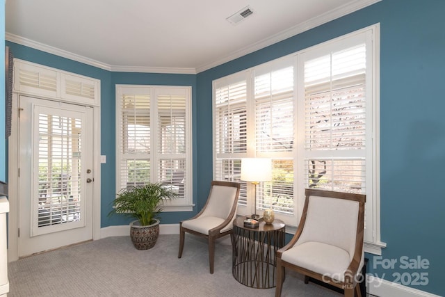 living area with plenty of natural light, ornamental molding, and carpet floors