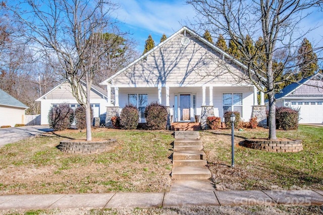 view of front facade with a front yard, covered porch, a garage, and an outdoor structure