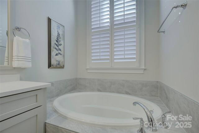 bathroom with a relaxing tiled tub and vanity