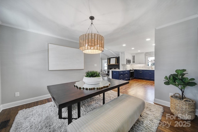 dining space with crown molding and dark hardwood / wood-style flooring