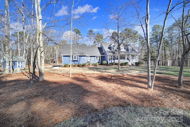 cape cod house featuring a storage unit