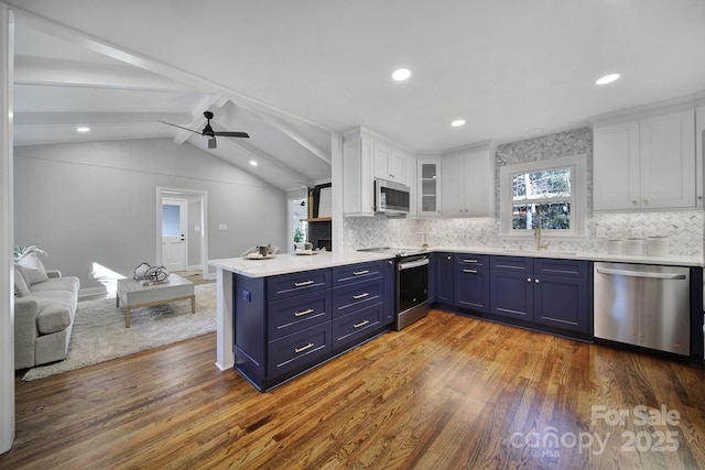 kitchen featuring appliances with stainless steel finishes, vaulted ceiling with beams, dark hardwood / wood-style floors, white cabinets, and blue cabinets