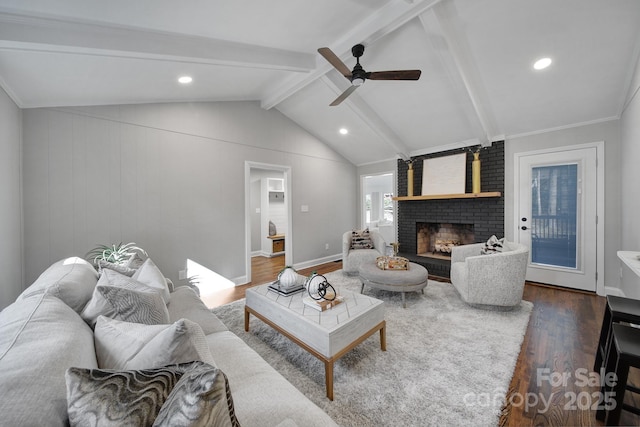 living room featuring a fireplace, dark wood-type flooring, vaulted ceiling with beams, and ceiling fan