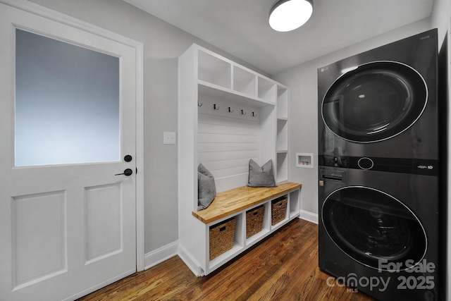 laundry room with stacked washing maching and dryer and dark hardwood / wood-style floors