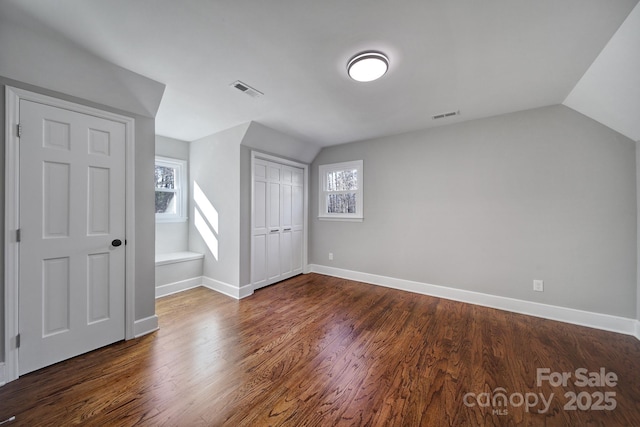 additional living space featuring lofted ceiling and dark hardwood / wood-style flooring