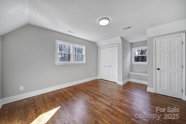 bonus room featuring dark wood-type flooring, a healthy amount of sunlight, and vaulted ceiling