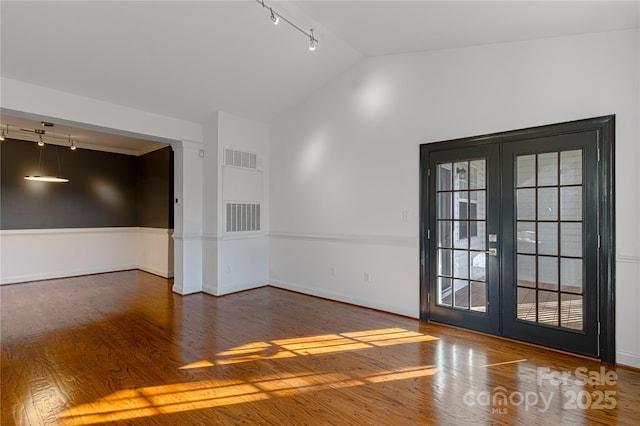 spare room with dark hardwood / wood-style floors and lofted ceiling