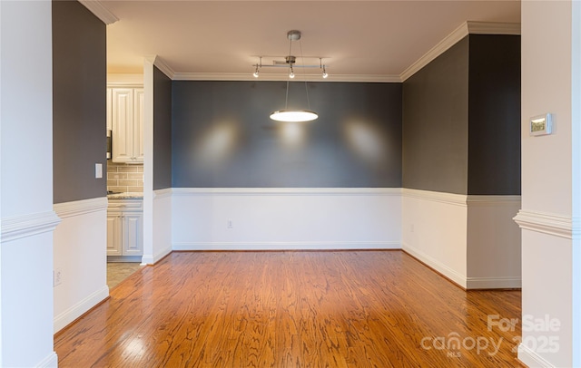 empty room featuring light hardwood / wood-style flooring and crown molding