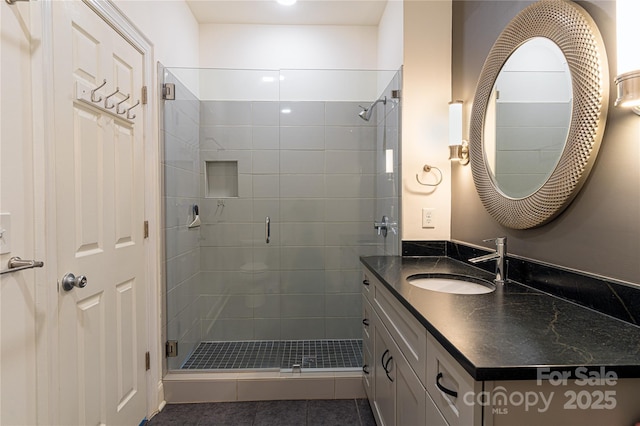 bathroom with tile patterned flooring, vanity, and a shower with door