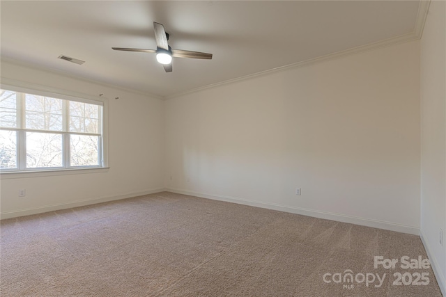 carpeted spare room with ceiling fan and ornamental molding