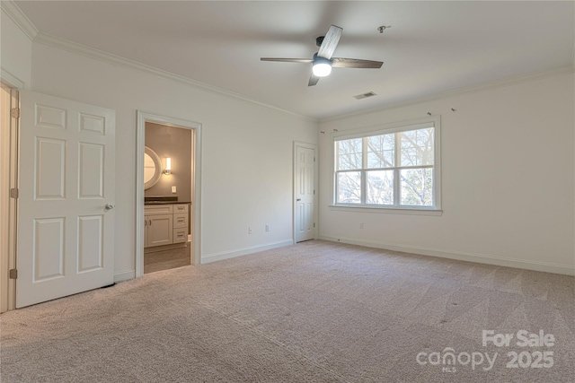 unfurnished bedroom with ensuite bath, ceiling fan, crown molding, and light carpet