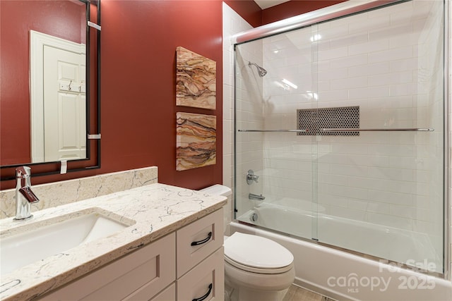 full bathroom with vanity, toilet, and shower / bath combination with glass door