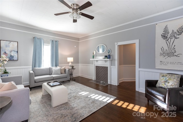 living room with crown molding, ceiling fan, and dark wood-type flooring