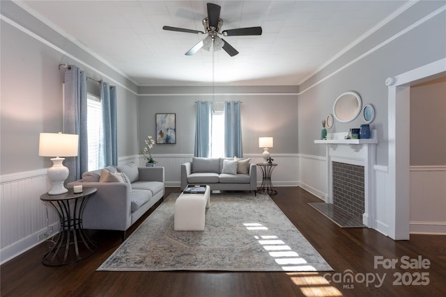 living room featuring plenty of natural light, ceiling fan, dark wood-type flooring, and a tiled fireplace