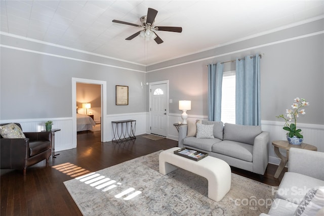 living room featuring dark hardwood / wood-style flooring, ceiling fan, and crown molding