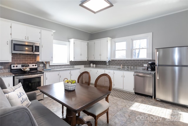 kitchen featuring a wealth of natural light, white cabinets, and stainless steel appliances