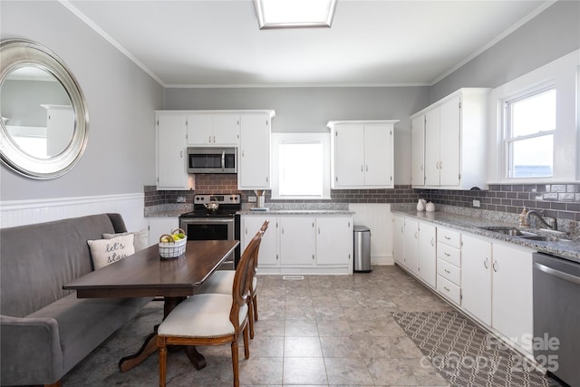 kitchen featuring white cabinets, light stone countertops, sink, and appliances with stainless steel finishes