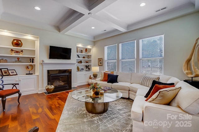 living room featuring hardwood / wood-style flooring, coffered ceiling, built in features, and beam ceiling