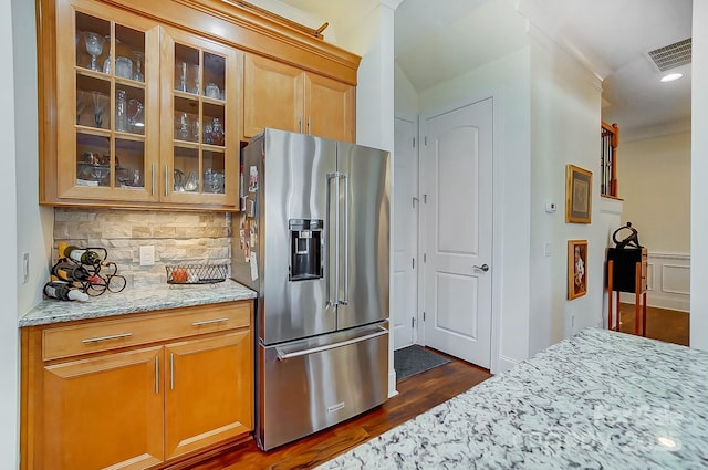 kitchen featuring light stone counters, tasteful backsplash, and high quality fridge