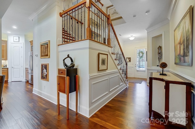 stairway featuring ornamental molding and wood-type flooring