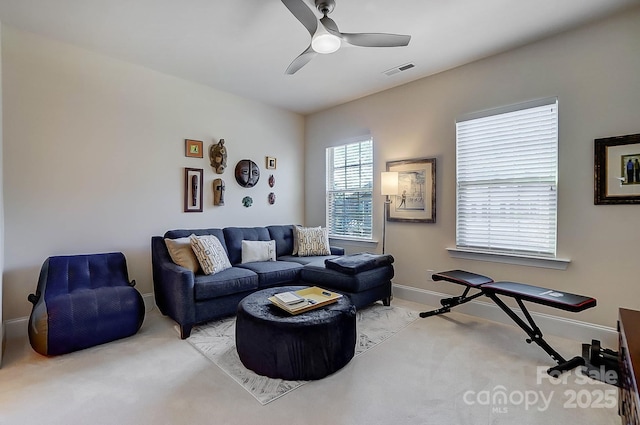 carpeted living room with ceiling fan