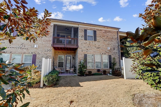 rear view of house with a balcony and a sunroom