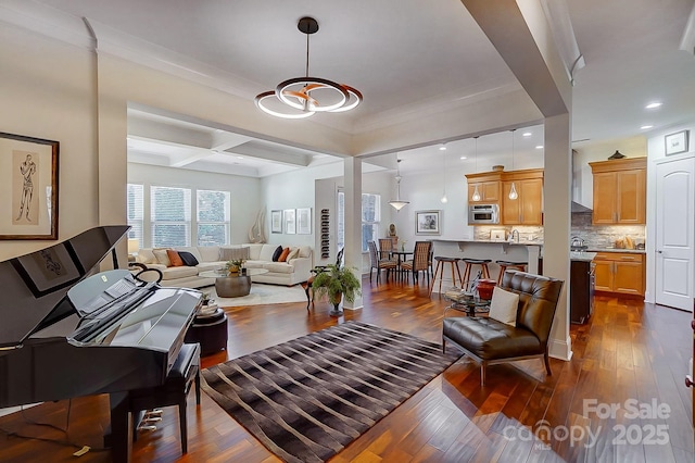 living room with beamed ceiling, ornamental molding, coffered ceiling, and dark wood-type flooring