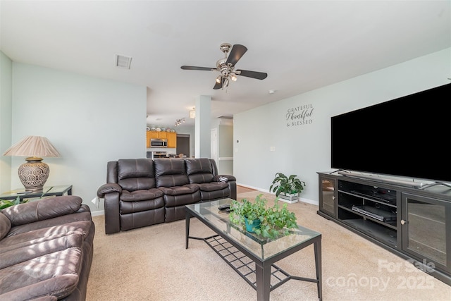 carpeted living room with ceiling fan